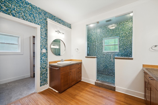 924 E 27th St, Houston, TX 77009 - bathroom with vanity, wood finished floors, a stall shower, and baseboards