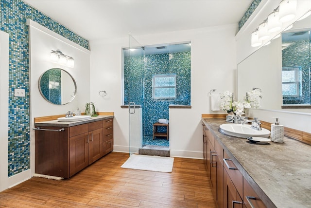924 E 27th St, Houston, TX 77009 - full bath featuring a shower stall, baseboards, wood finished floors, and two vanities