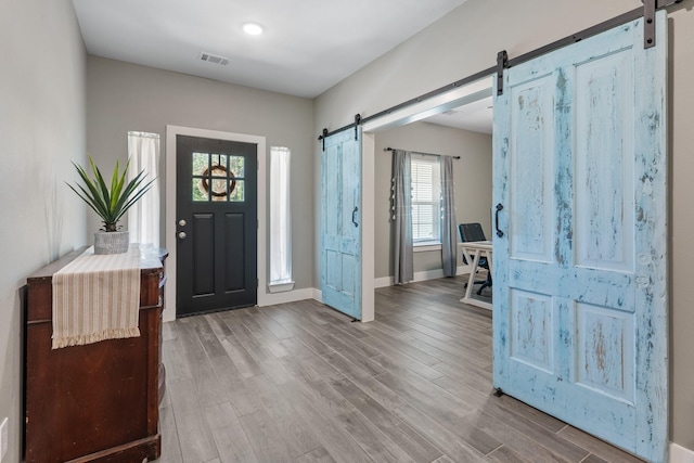 8729 Nathan Dr, Waller, TX 77484 - foyer featuring a barn door, wood finished floors, and baseboards