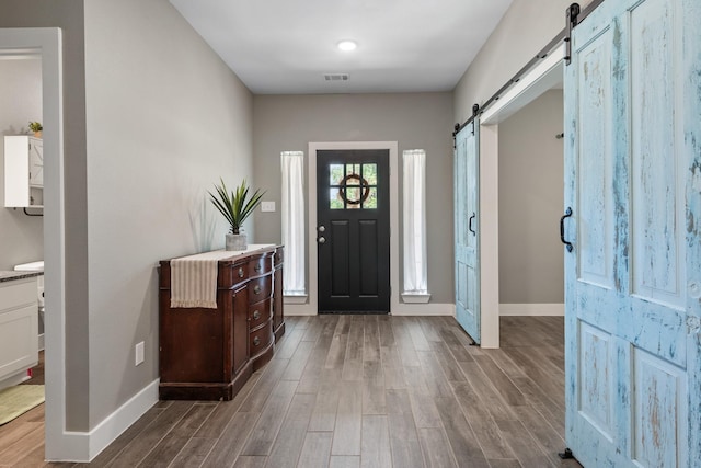 8729 Nathan Dr, Waller, TX 77484 - foyer with a barn door, baseboards, and wood finished floors
