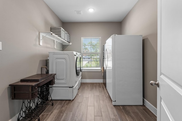 8729 Nathan Dr, Waller, TX 77484 - laundry room with washer / dryer, wood finished floors, and baseboards