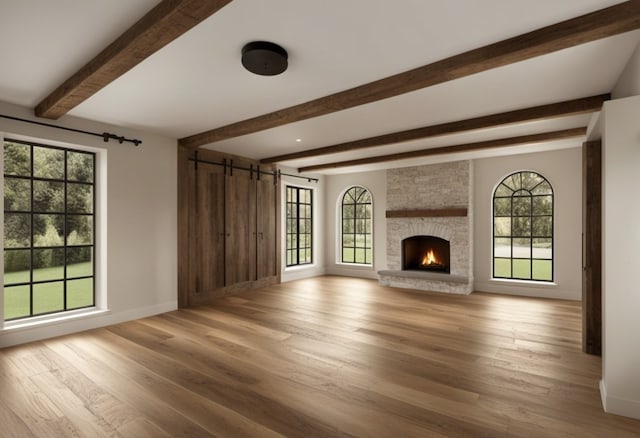 5211 Olympia Fields Ln, Houston, TX 77069 - unfurnished living room featuring beamed ceiling, light wood-type flooring, baseboards, a barn door, and a fireplace