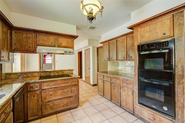 5211 Olympia Fields Ln, Houston, TX 77069 - kitchen with black appliances, under cabinet range hood, light tile patterned floors, decorative backsplash, and stone countertops