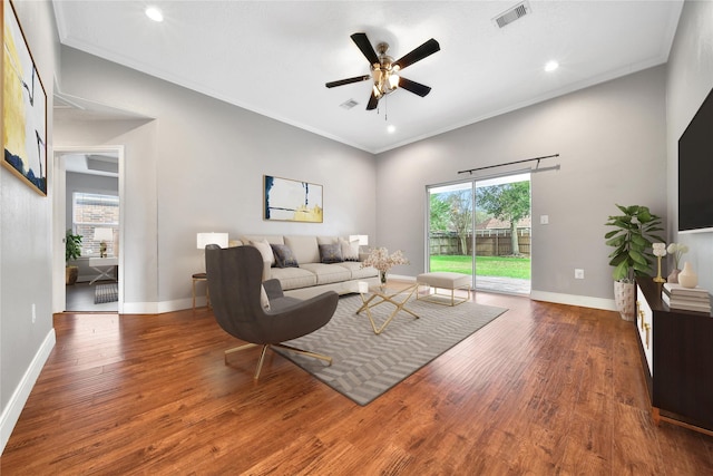 living area with ceiling fan, wood finished floors, crown molding, baseboards, and recessed lighting