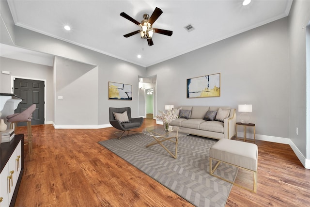 living room with ceiling fan, wood finished floors, baseboards, recessed lighting, and crown molding