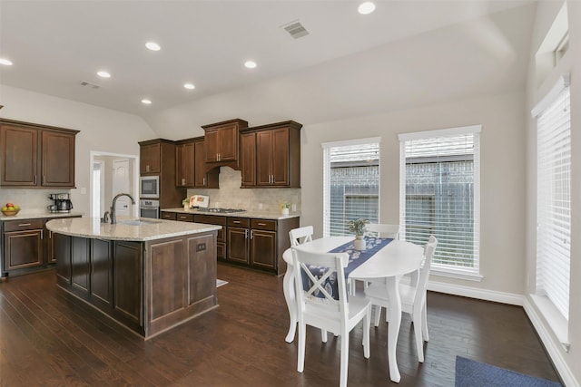 16819 Big Reed Dr, Humble, TX 77346 - kitchen featuring stainless steel appliances, decorative backsplash, dark brown cabinets, dark wood-type flooring, and a sink