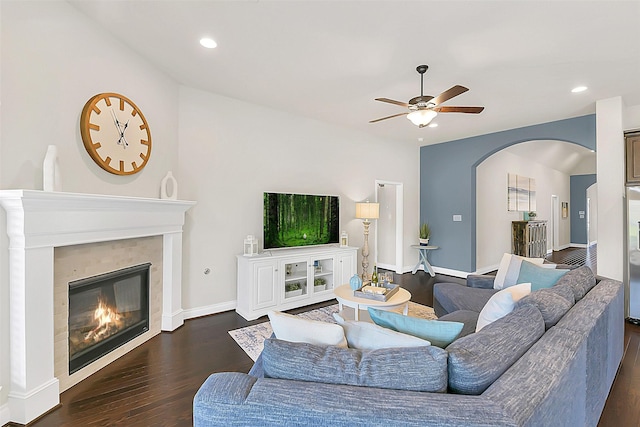 16819 Big Reed Dr, Humble, TX 77346 - living area featuring dark wood-style floors, ceiling fan, arched walkways, a glass covered fireplace, and recessed lighting