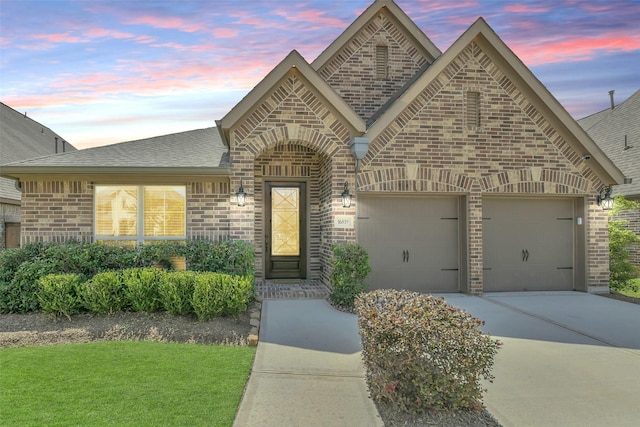 16819 Big Reed Dr, Humble, TX 77346 - french country inspired facade featuring brick siding, driveway, roof with shingles, and an attached garage