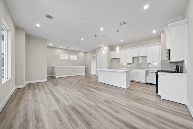 9 Wellford St Unit F, Houston, TX 77022 - kitchen with a kitchen island, a sink, backsplash, white cabinets, and open floor plan