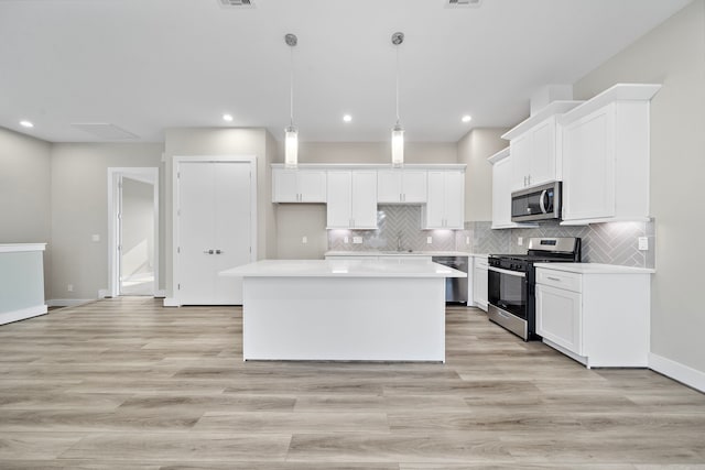 9 Wellford St Unit F, Houston, TX 77022 - kitchen featuring appliances with stainless steel finishes, a sink, a kitchen island, white cabinets, and recessed lighting