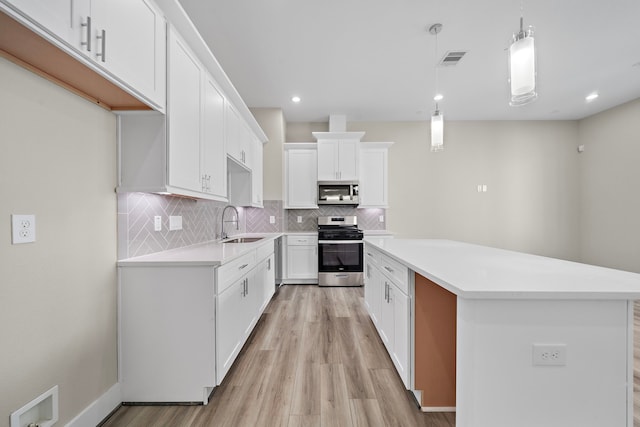 9 Wellford St Unit F, Houston, TX 77022 - kitchen with appliances with stainless steel finishes, tasteful backsplash, a sink, light wood-style flooring, and recessed lighting