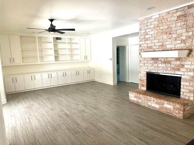 3007 Broadmoor Dr, Sugar Land, TX 77478 - unfurnished living room featuring a ceiling fan, baseboards, a fireplace, and wood finished floors