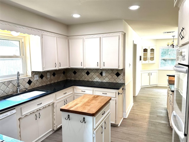 3007 Broadmoor Dr, Sugar Land, TX 77478 - kitchen with a sink, butcher block countertops, white cabinets, backsplash, and wood finished floors