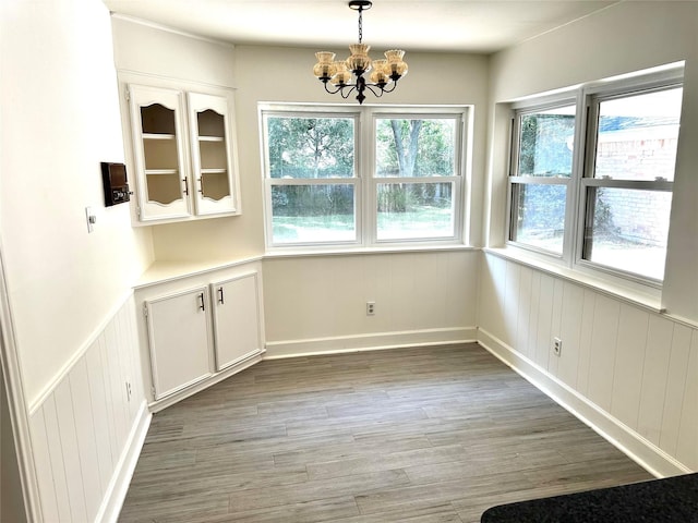 3007 Broadmoor Dr, Sugar Land, TX 77478 - unfurnished dining area with a chandelier, light wood finished floors, wainscoting, and baseboards