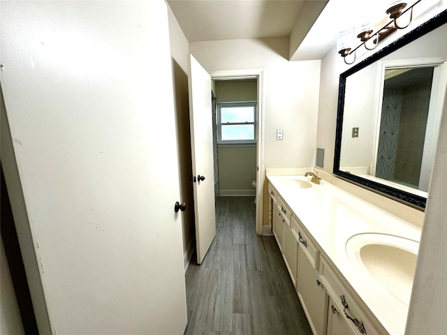 3007 Broadmoor Dr, Sugar Land, TX 77478 - bathroom with double vanity, wood finished floors, toilet, and baseboards