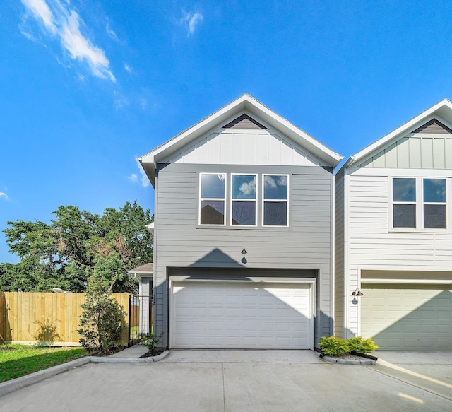 11 Wellford St Unit G, Houston, TX 77022 - view of front of home with a garage, board and batten siding, fence, and driveway