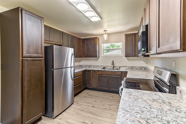 401 S Fig St, Sweeny, TX 77480 - kitchen with appliances with stainless steel finishes, light wood-type flooring, and a sink