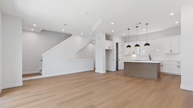 3605 Mount Pleasant St, Houston, TX 77021 - kitchen with white cabinets, a kitchen island, light wood-type flooring, recessed lighting, and light countertops