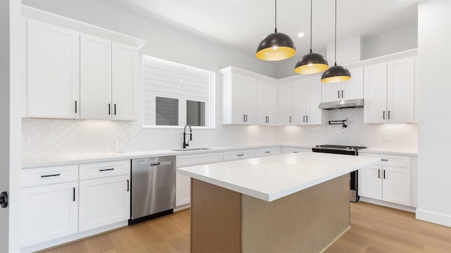 3605 Mount Pleasant St, Houston, TX 77021 - kitchen featuring stainless steel appliances, under cabinet range hood, a sink, light countertops, and tasteful backsplash