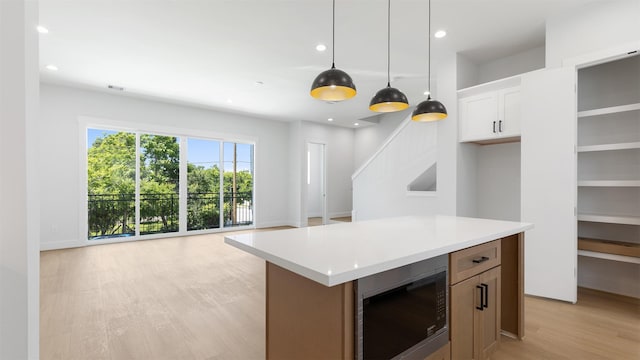 3605 Mount Pleasant St, Houston, TX 77021 - kitchen featuring built in microwave, light wood-style floors, recessed lighting, decorative light fixtures, and light countertops