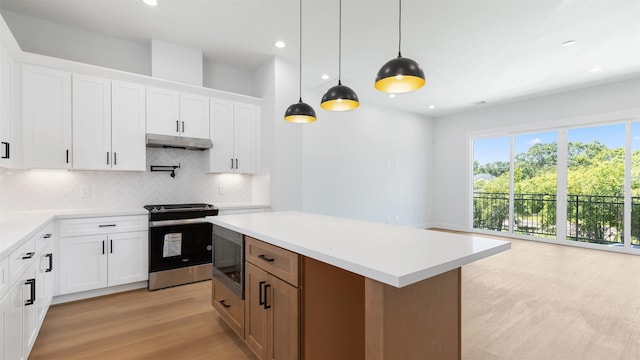 3605 Mount Pleasant St, Houston, TX 77021 - kitchen featuring stainless steel electric range oven, built in microwave, backsplash, under cabinet range hood, and light countertops