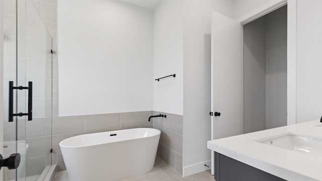 3605 Mount Pleasant St, Houston, TX 77021 - full bathroom with tile walls, a soaking tub, a shower stall, vanity, and tile patterned flooring