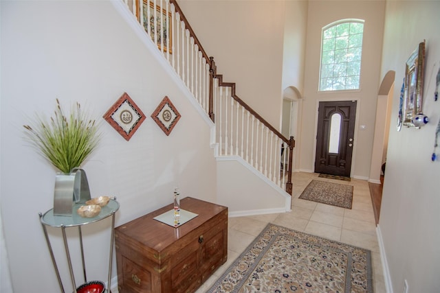 20018 Rene Creek Ct, Spring, TX 77388 - foyer featuring arched walkways, a towering ceiling, light tile patterned flooring, stairway, and baseboards