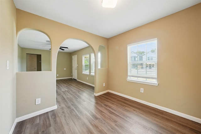 3615 Seabrook St, Houston, TX 77021 - spare room with wood finished floors, baseboards, arched walkways, and a ceiling fan