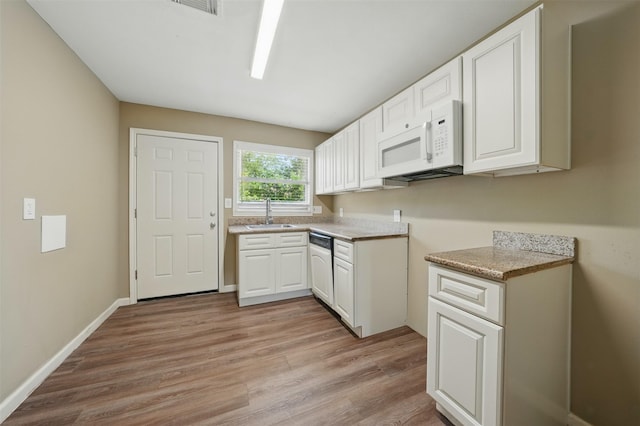 3615 Seabrook St, Houston, TX 77021 - kitchen with white appliances, light wood-style flooring, white cabinetry, light countertops, and a sink