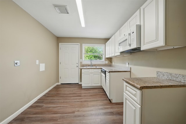 3615 Seabrook St, Houston, TX 77021 - kitchen with a sink, white microwave, light wood-style floors, and white cabinets