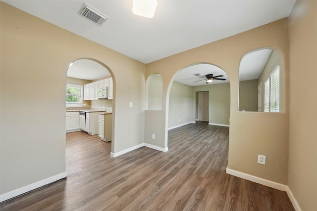 3615 Seabrook St, Houston, TX 77021 - spare room featuring arched walkways, a ceiling fan, baseboards, and wood finished floors