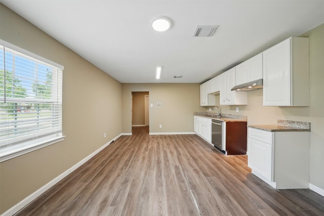 3615 Seabrook St, Houston, TX 77021 - kitchen with stainless steel dishwasher, light wood-type flooring, baseboards, and white cabinetry