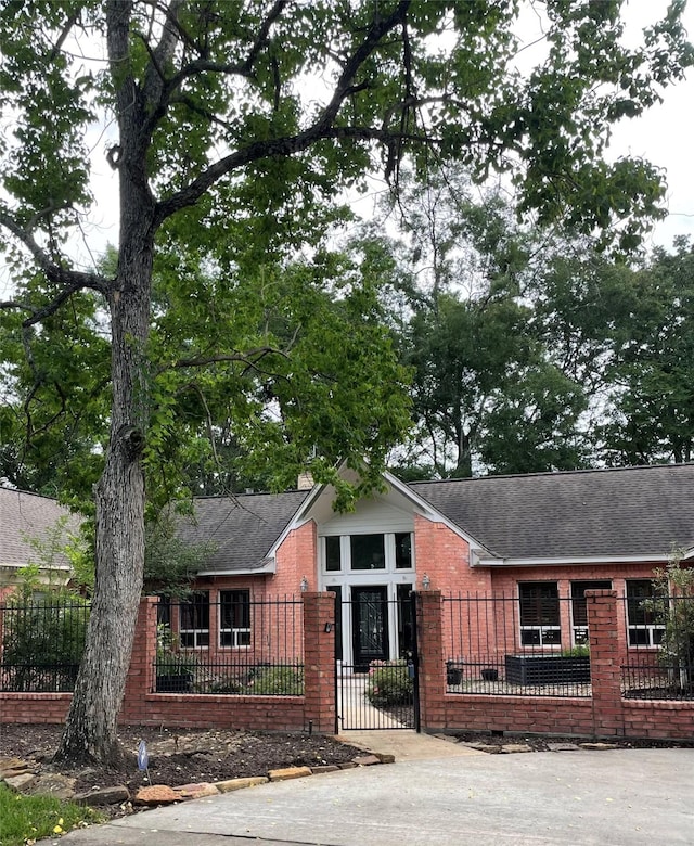 10611 Crystal Cove Dr, Magnolia, TX 77354 - view of front facade with brick siding, roof with shingles, and a fenced front yard