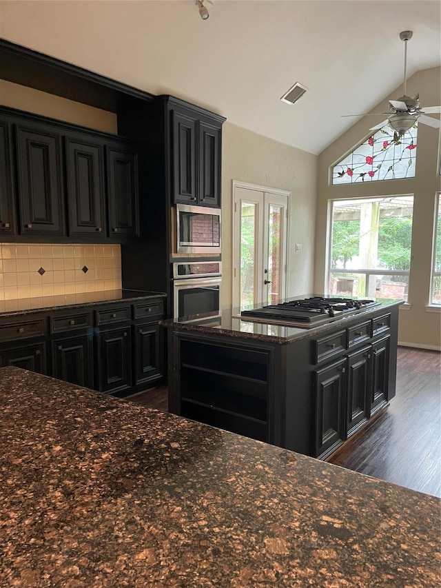 10611 Crystal Cove Dr, Magnolia, TX 77354 - kitchen featuring stainless steel appliances, dark cabinetry, dark wood finished floors, lofted ceiling, and ceiling fan