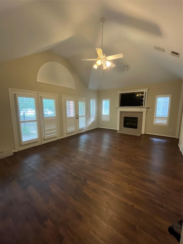 10611 Crystal Cove Dr, Magnolia, TX 77354 - unfurnished living room with dark wood-type flooring, a tile fireplace, a ceiling fan, baseboards, and high vaulted ceiling