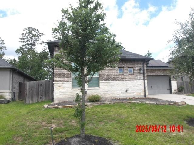 3817 Hawthorn Shadow Ct, Spring, TX 77386 - view of side of home with stone siding, concrete driveway, a garage, and brick siding