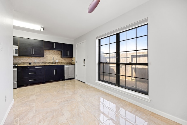 10328 Longmont Dr Unit 47/1, Houston, TX 77042 - kitchen with white microwave, stainless steel dishwasher, a sink, dark cabinetry, and baseboards
