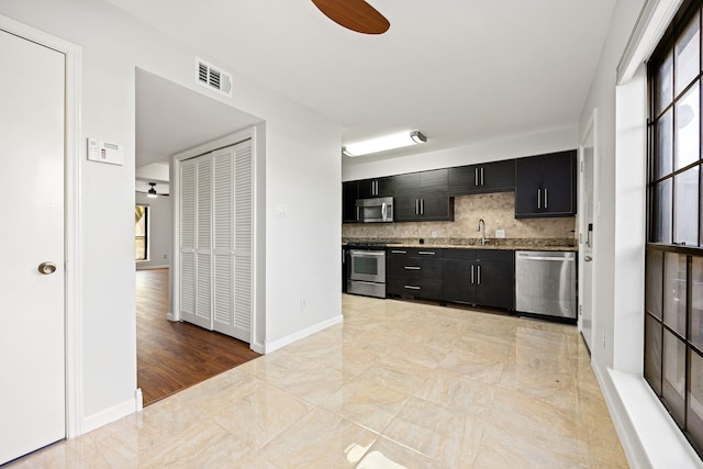 10328 Longmont Dr Unit 47/1, Houston, TX 77042 - kitchen featuring appliances with stainless steel finishes, dark cabinets, a sink, backsplash, and a ceiling fan