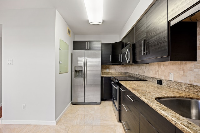 10328 Longmont Dr Unit 47/1, Houston, TX 77042 - kitchen with appliances with stainless steel finishes, light stone countertops, baseboards, decorative backsplash, and a sink