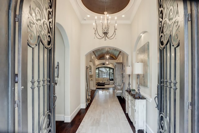 6206 Terwilliger Way, Houston, TX 77057 - foyer featuring arched walkways, dark wood-type flooring, a chandelier, a tray ceiling, and baseboards