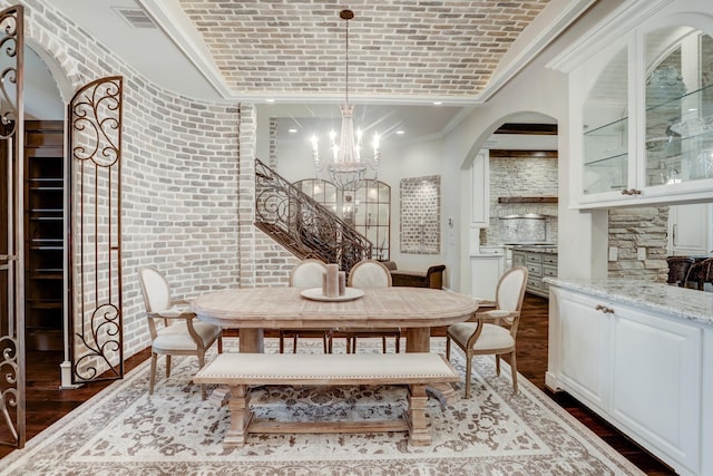 6206 Terwilliger Way, Houston, TX 77057 - dining room featuring dark wood-style flooring, a chandelier, arched walkways, ornamental molding, and brick ceiling