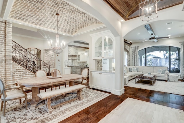 6206 Terwilliger Way, Houston, TX 77057 - dining area with dark wood finished floors, ceiling fan, a chandelier, stairs, and brick ceiling