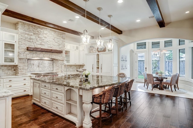 6206 Terwilliger Way, Houston, TX 77057 - kitchen featuring arched walkways, beamed ceiling, open shelves, backsplash, and dark wood-style floors