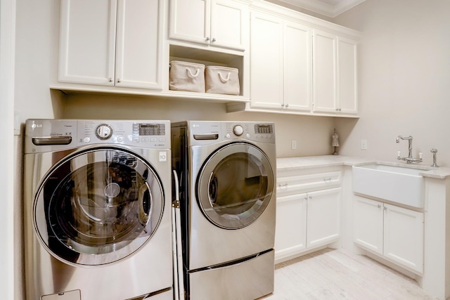 6206 Terwilliger Way, Houston, TX 77057 - clothes washing area featuring washing machine and clothes dryer, cabinet space, and crown molding