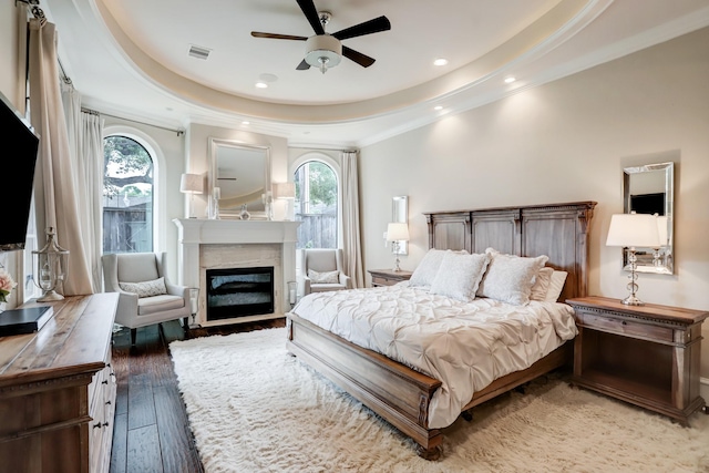 6206 Terwilliger Way, Houston, TX 77057 - bedroom with a tray ceiling, a glass covered fireplace, crown molding, hardwood / wood-style floors, and recessed lighting