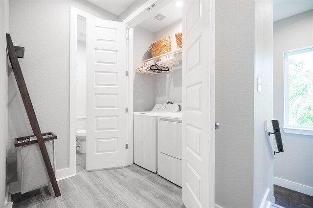 12422 Texas Army Trl, Cypress, TX 77429 - washroom with washing machine and dryer, light wood-style flooring, healthy amount of natural light, and baseboards
