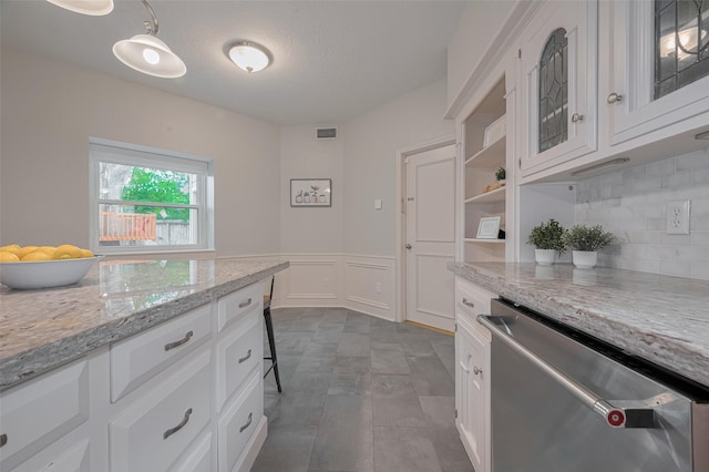 12438 Piping Rock Dr, Houston, TX 77077 - kitchen with stainless steel dishwasher, a decorative wall, white cabinets, backsplash, and wainscoting