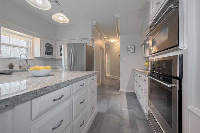 12438 Piping Rock Dr, Houston, TX 77077 - kitchen with appliances with stainless steel finishes, white cabinetry, light stone counters, and glass insert cabinets