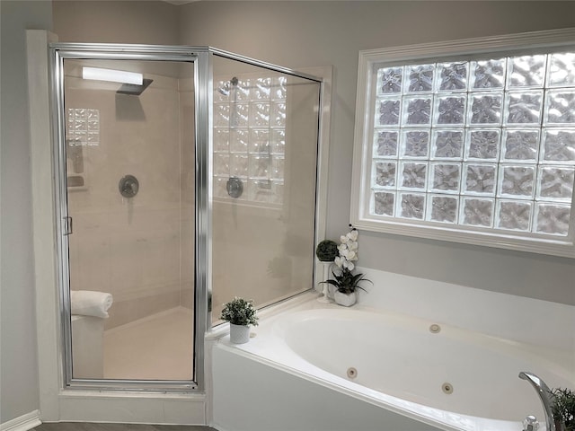 full bath with a tub with jets and a stall shower