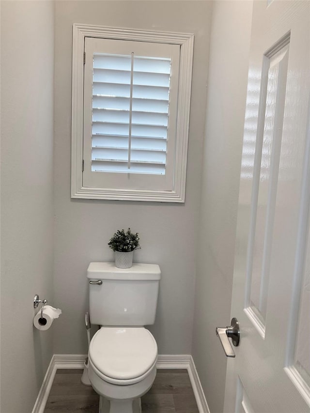 bathroom featuring baseboards, toilet, and wood finished floors